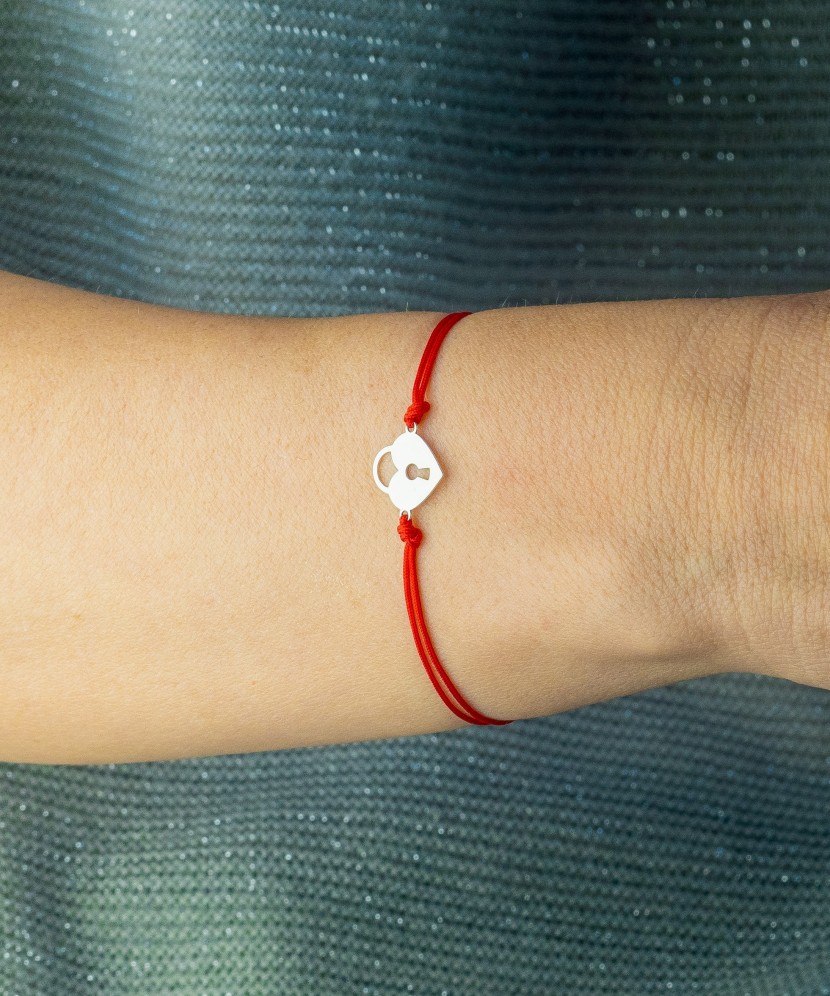 Браслет из красной нити с серебряной подвеской