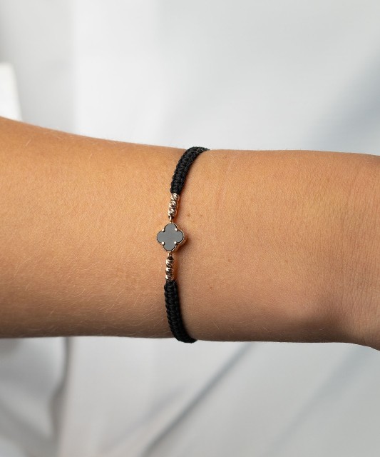 Mustast lõngast käevõru kulla ja oonüksitega