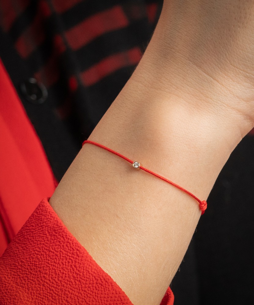 Punasest lõngas käevõru  kullast ja briljandist ripatsiga 0.05ct