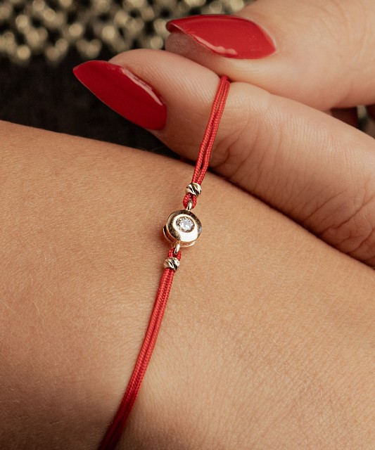 Punasest lõngast käevõru kulla tsirkoonist ripatsiga