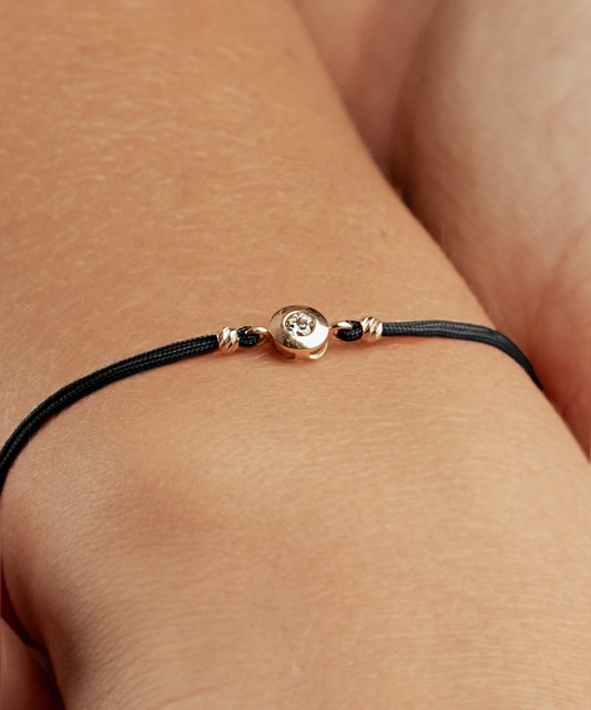 Mustast lõngast käevõru kuldripatsiga