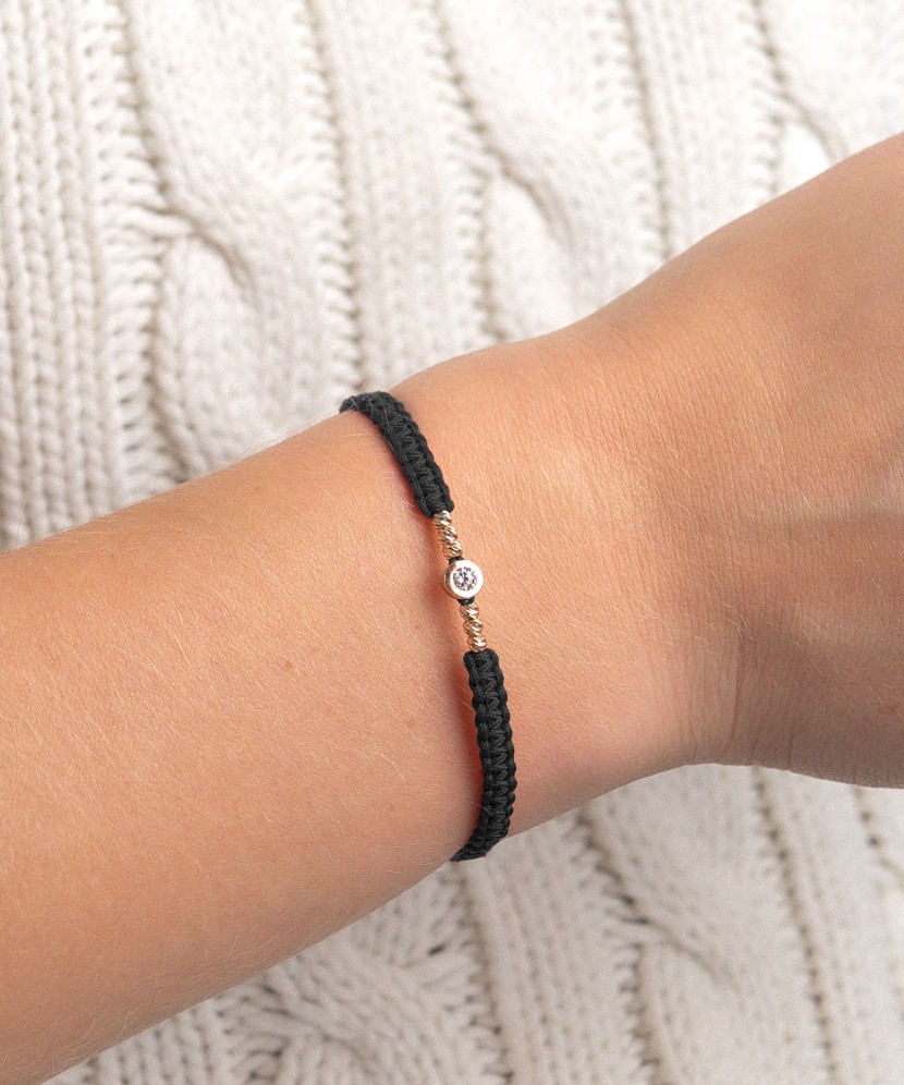 Mustast lõngast käevõru kuldripatsiga