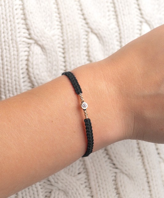 Mustast lõngast käevõru kuldripatsiga