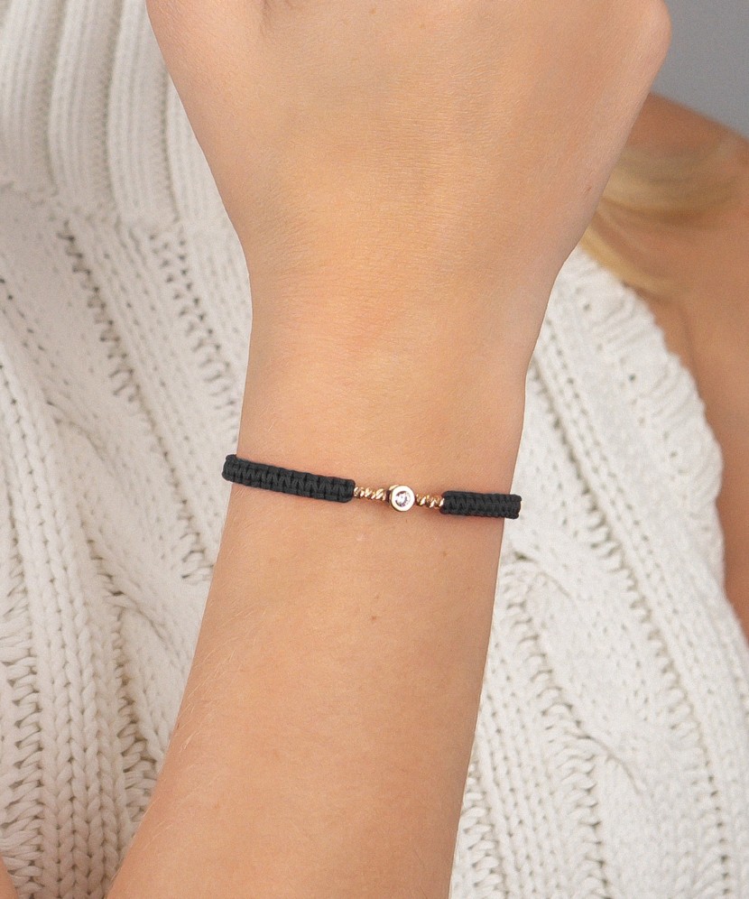 Mustast lõngast käevõru kuldripatsiga