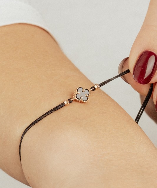 Mustast lõngast käevõru kulla ja oonüksitega