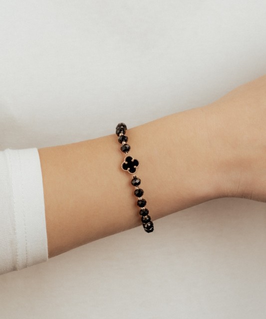 Mustast lõngast käevõru kulla ja oonüksitega