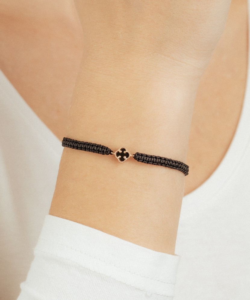 Mustast lõngast käevõru kulla ja oonüksitega