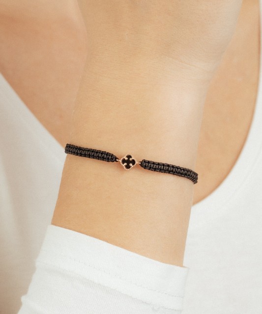 Mustast lõngast käevõru kulla ja oonüksitega