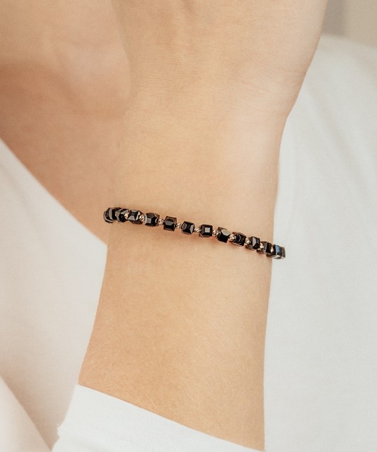 Mustast lõngast käevõru kulla ja oonüksitega