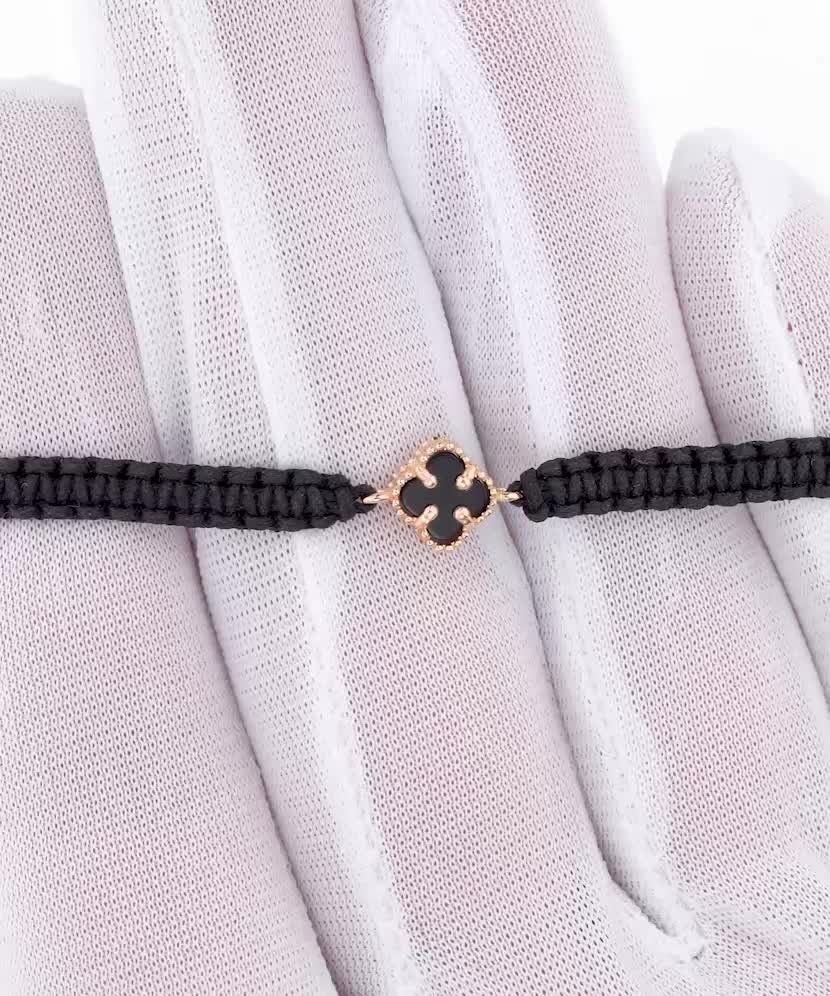 Mustast lõngast käevõru kulla ja oonüksitega