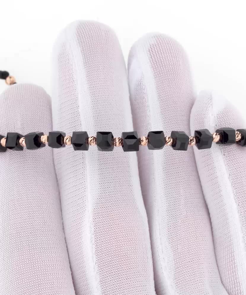 Mustast lõngast käevõru kulla ja oonüksitega