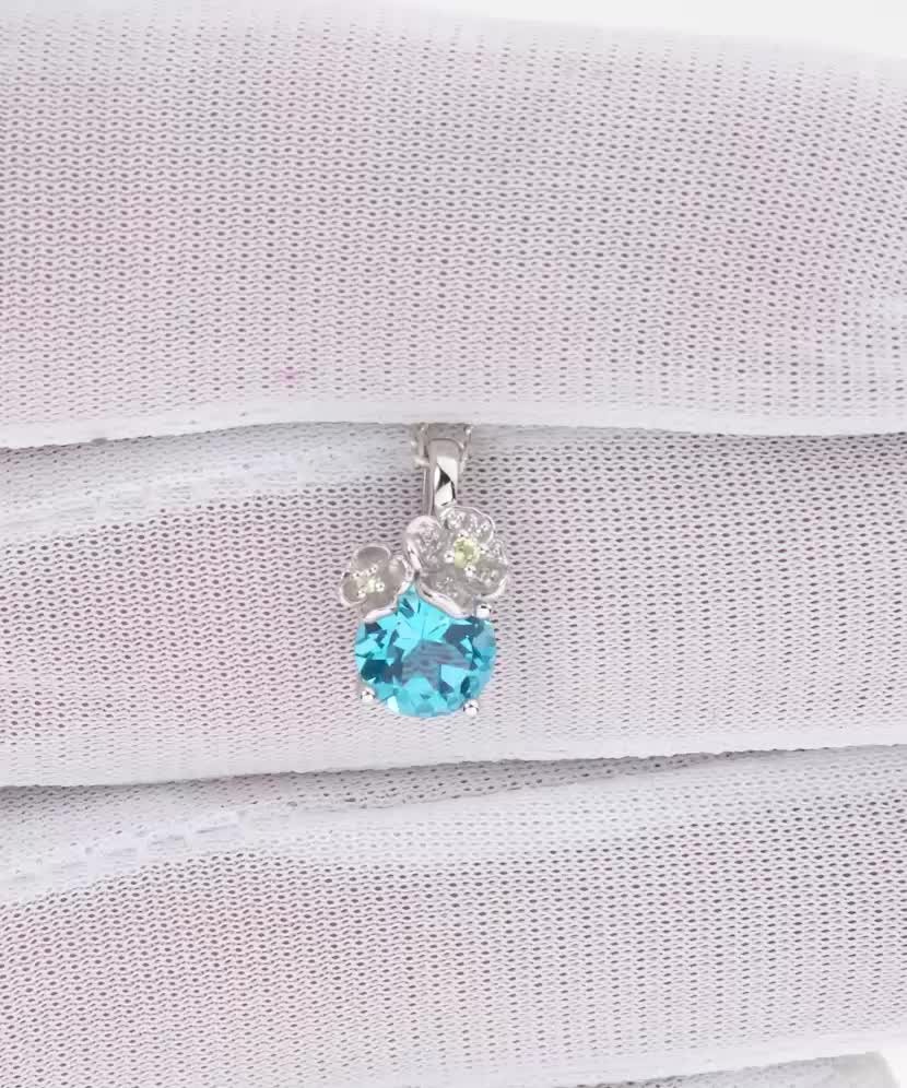 Кулон из белого золота с топазами, бриллиантами и перидотами.