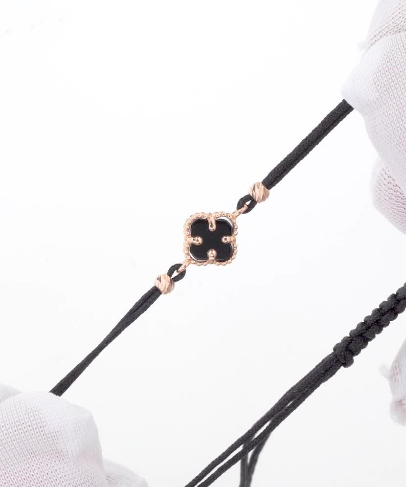 Mustast lõngast käevõru kulla ja oonüksitega